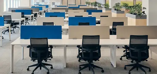 Modern open-plan office space featuring clean workstations, ergonomic chairs, and sanitized carpets provided by professional office cleaning services in Pembroke Pines, FL.